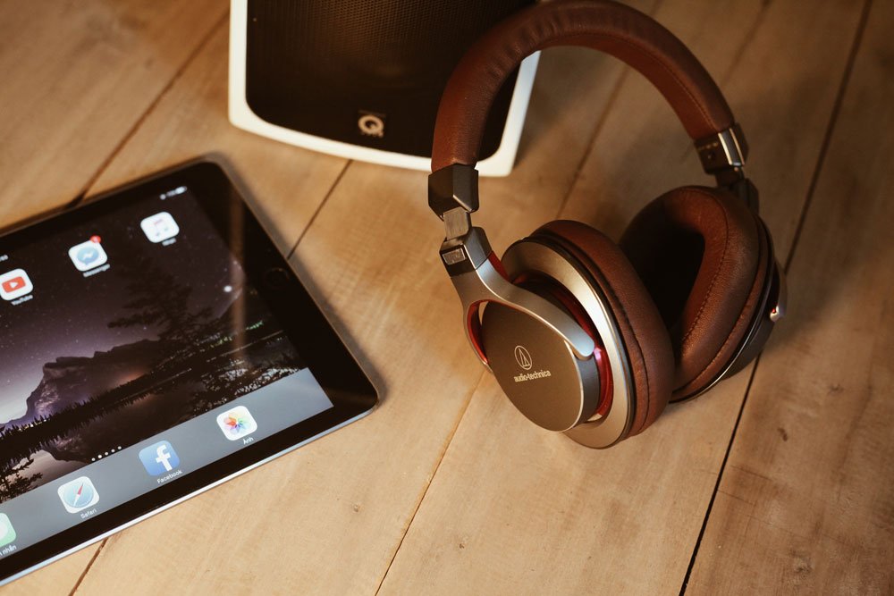 A pair of modern wireless Audio Technica headphones next to an iPad
